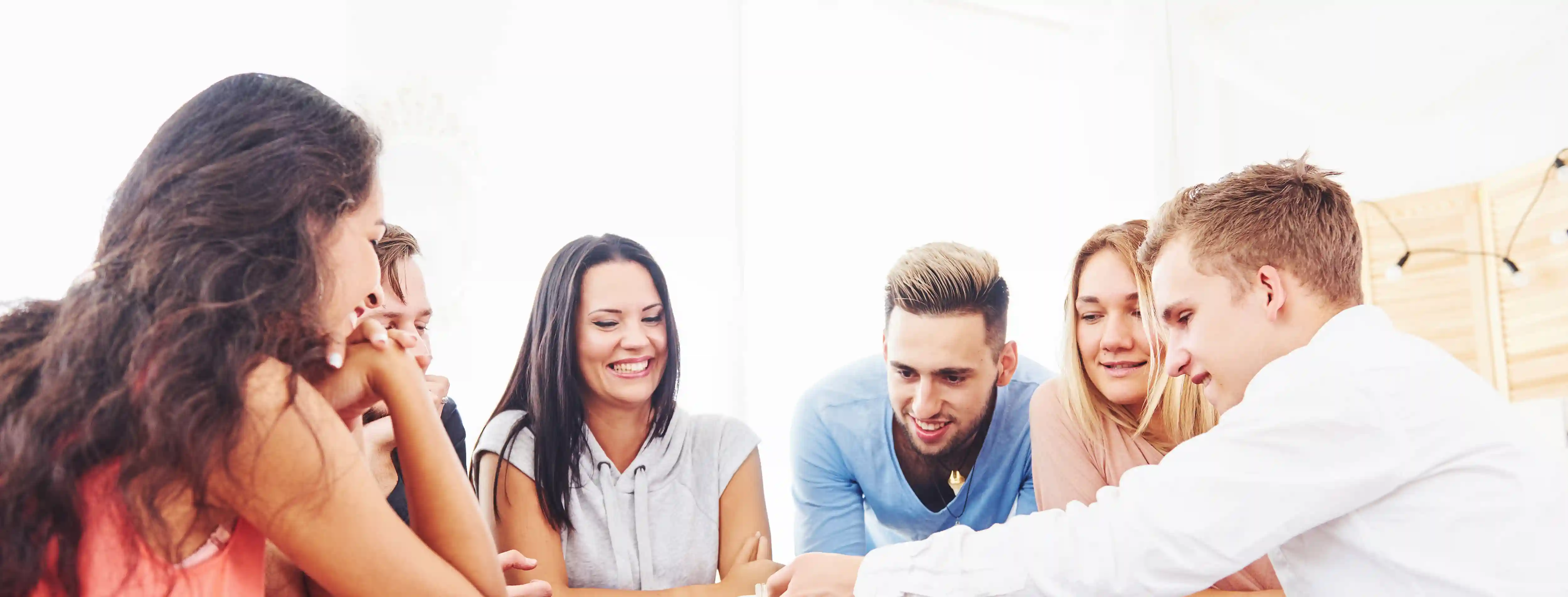 Sechs Personen sitzen zusammen und lachen