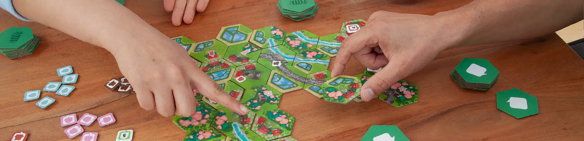 Zwei Personen spielen das Brettspiel Dorfromantik - Sakura
