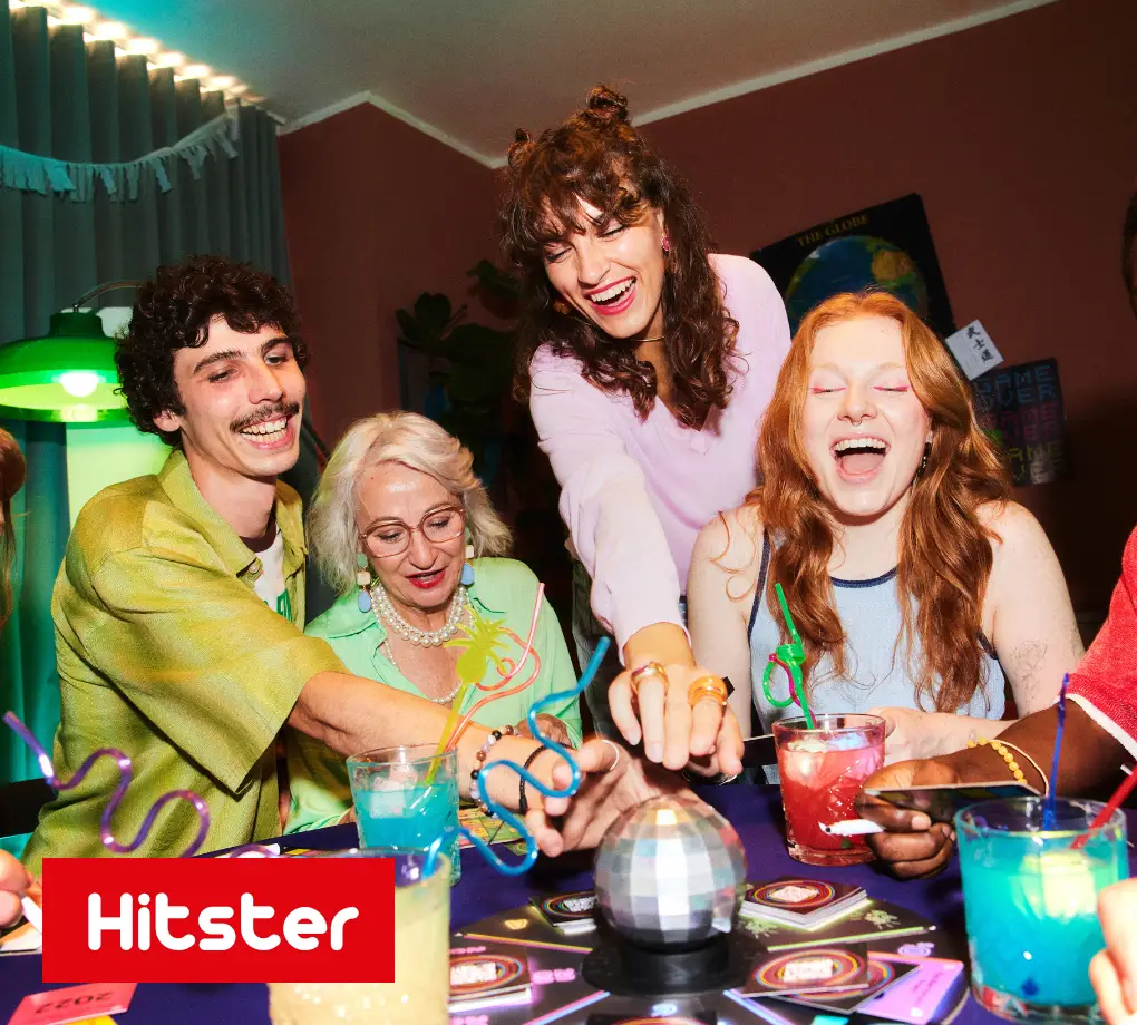Vier Personen spielen das Partyspiel Hitster Bingo