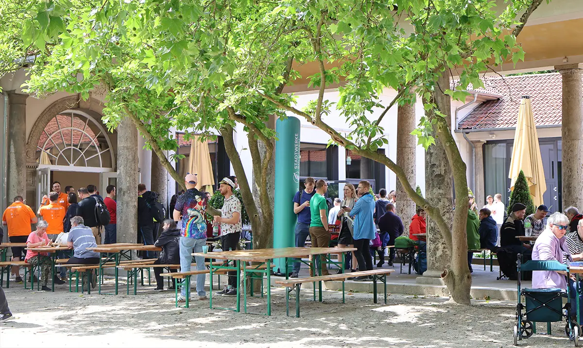Bierbänke und Tische mit Personen, die Spielen unter einem Baum