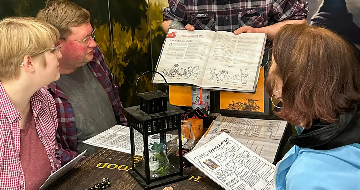 Spielgruppe blickt auf Charakterbögen des 5E Settings Humblewood